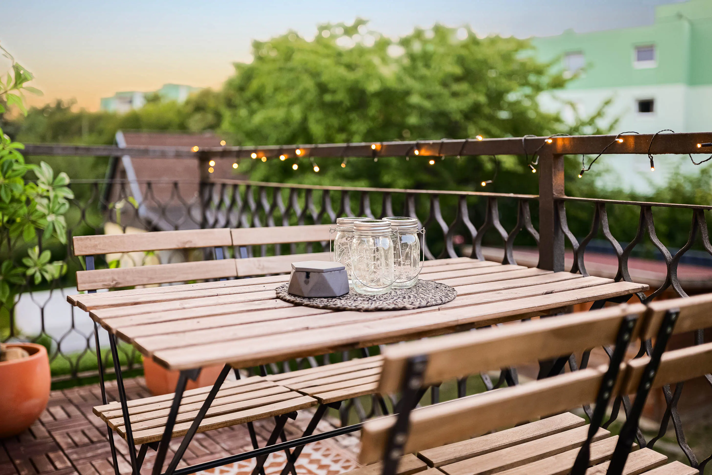 Furnished Jubili balcony with dining table and string lights