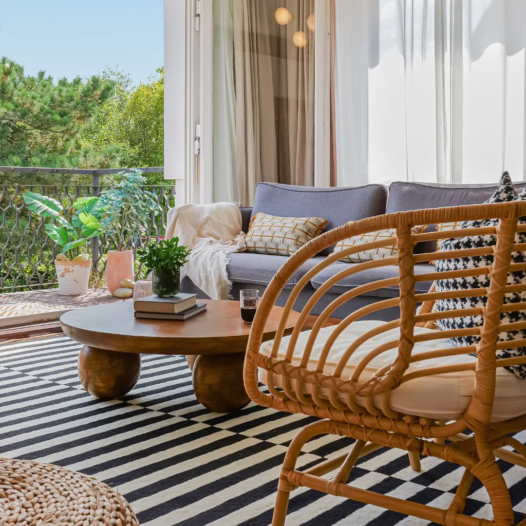 Jubili living room opening onto a leafy balcony